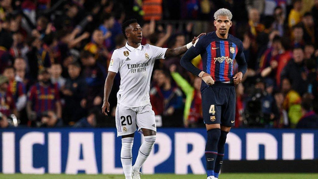 Real Madrid forward Vinicius Jr pats Ronald Araujo on the shoulder after the Barcelona defender's own goal