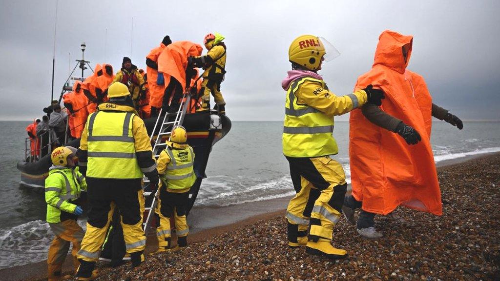 A person helps a migrant off a rescue boat