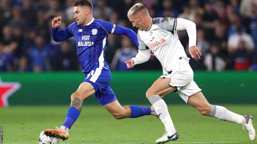 Aaron Ramsey of Cardiff City tries to get away from Jay Fulton of Swansea City