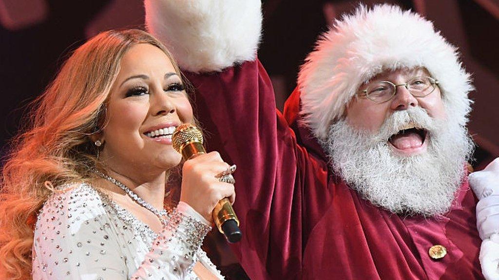 Mariah Carey with someone dressed as Santa Claus