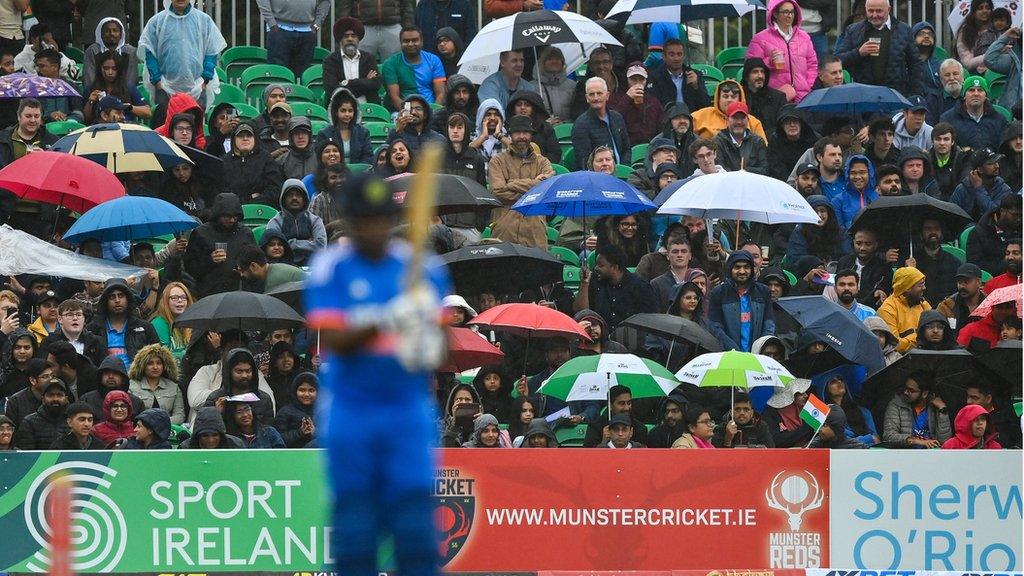 Umbrellas go up as rain rolls in to halt the action at Malahide