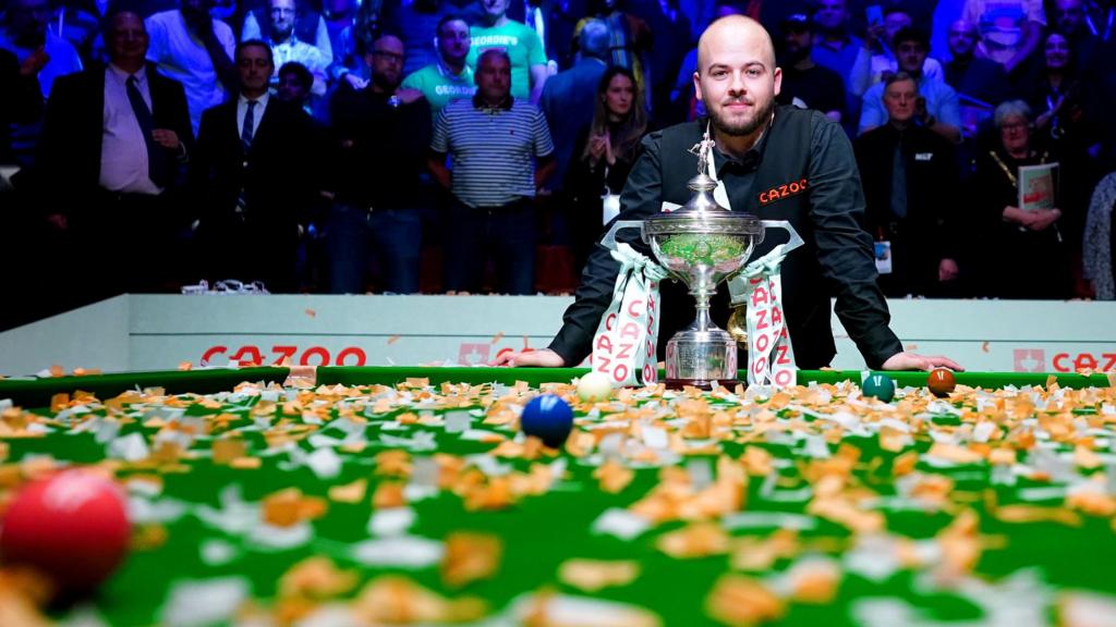 Luca Brecel celebrates with the World Championship trophy