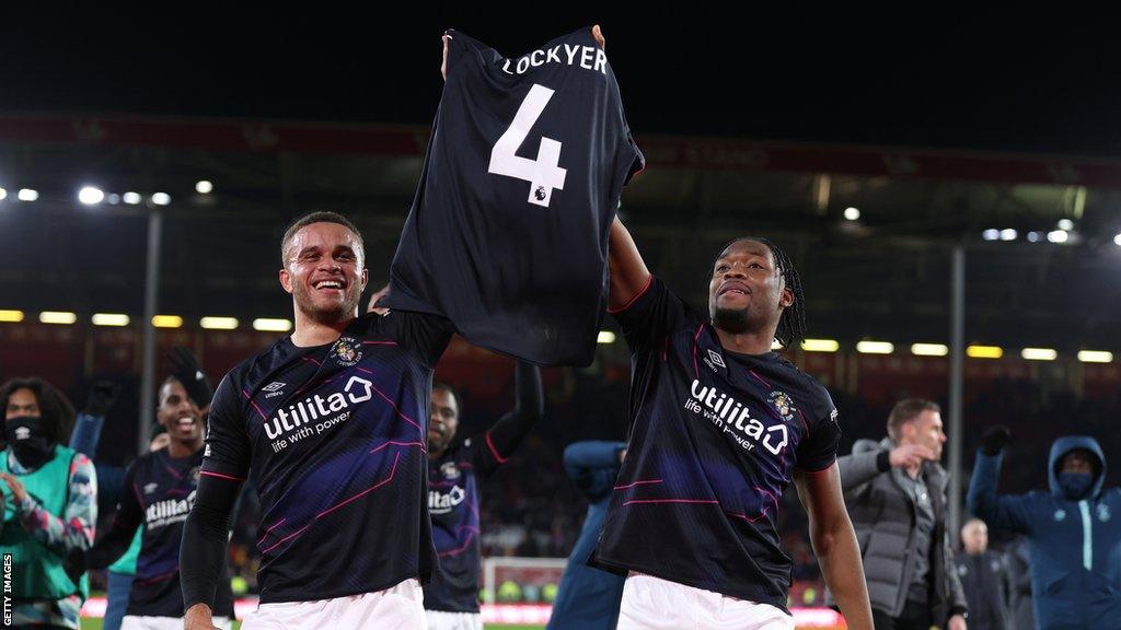 Teden Mengi and Carlton Morris of Luton Town celebrate victory raising a shirt with the name of injured teammate Tom Lockyer