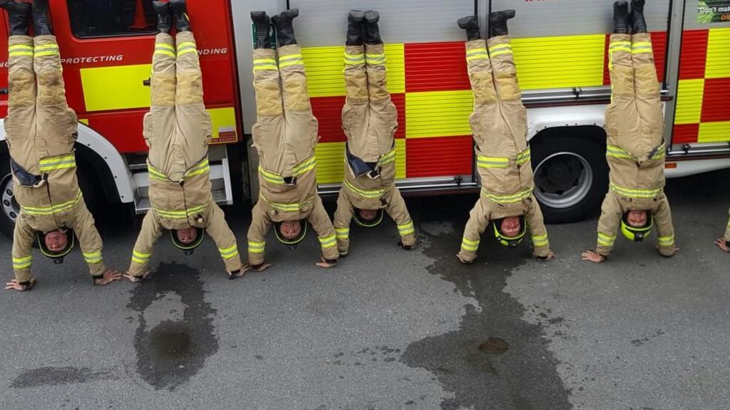 Firemen perform a handstand