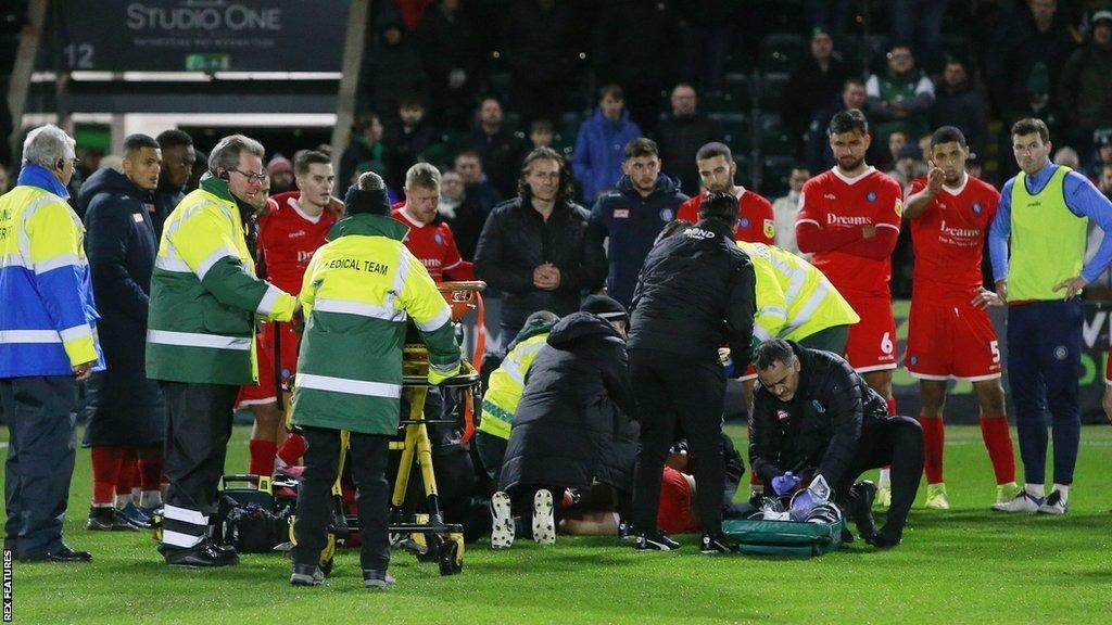 Wycombe's players formed a barrier around their fallen team-mate Tjay De Barr at Home Park