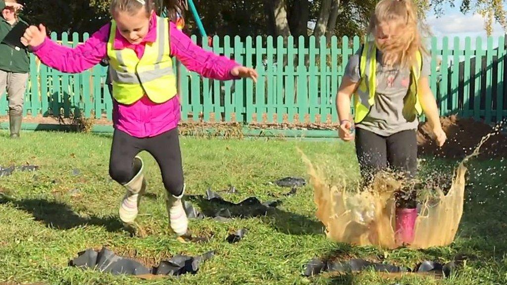 Children splashing in puddle