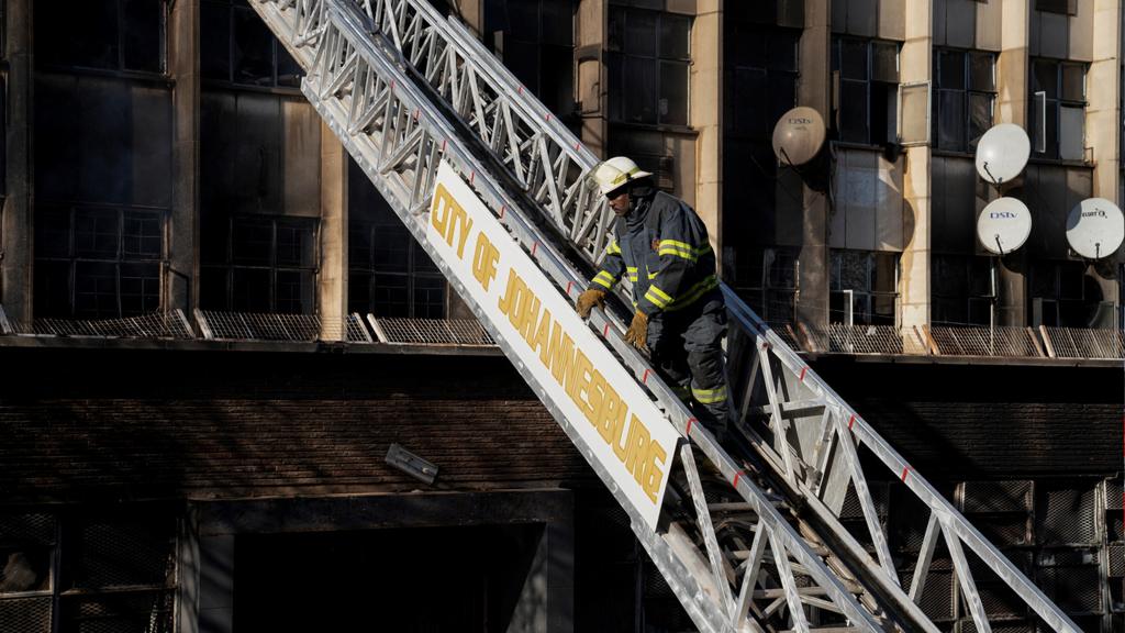 A firefighter works at the scene of a deadly fire which occurred in the early hours of the morning in Johannesburg, South Africa, on 31 August 2023