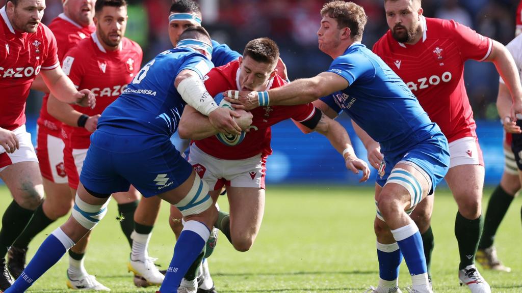 Josh Adams of Wales is tackled by Sebastian Negri and Lorenzo Cannone of Italy as (L-R) Ken Owens, Rhys Webb and Tomas Francis move in