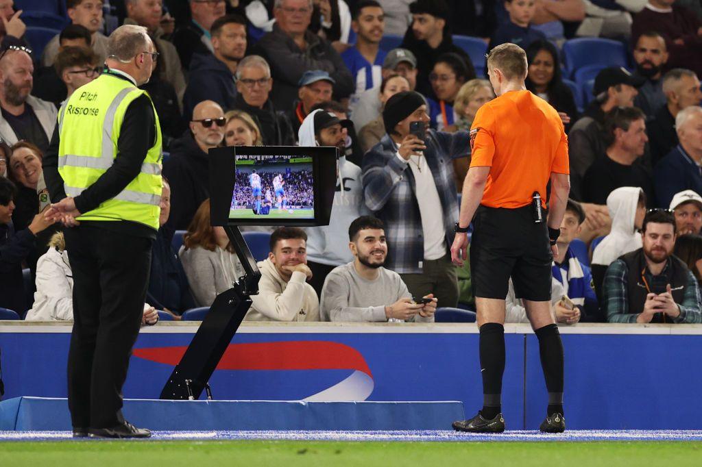 Referee looking at VAR screen