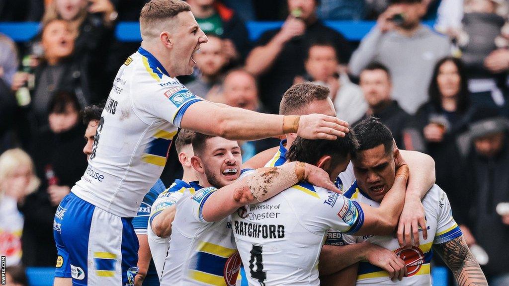 Warrington players flood in to pile on try-scorer Peter Mata'utia