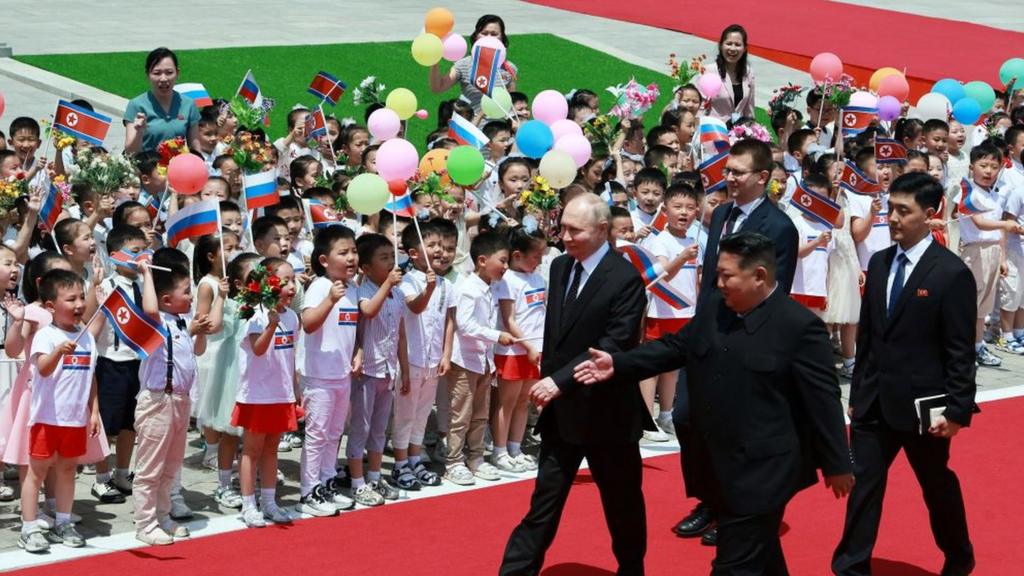 North Korea's leader Kim Jong Un (Center-R) and Russian President Vladimir Putin (L) walk past children during a welcoming ceremony at Kim Il Sung Square in Pyongyang on June 19, 2024.