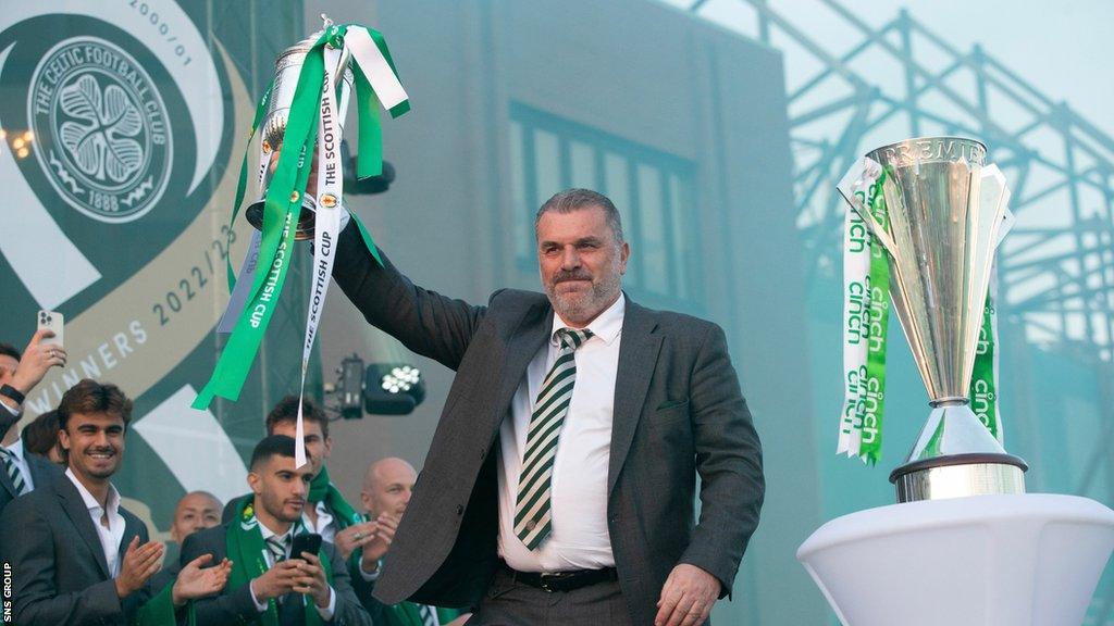 Ange Postecoglou is pictured as Celtic fans celebrate winning the Scottish Cup and completing the domestic treble at Celtic Park