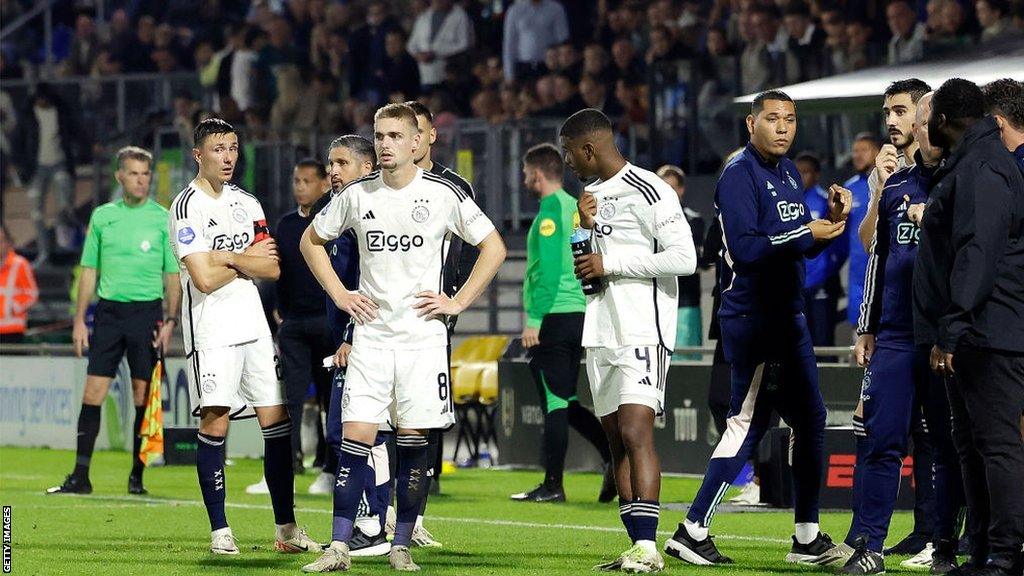 RKC Waalwijk and Ajax players await news of goalkeeper Etienne Vaessen after he was injured