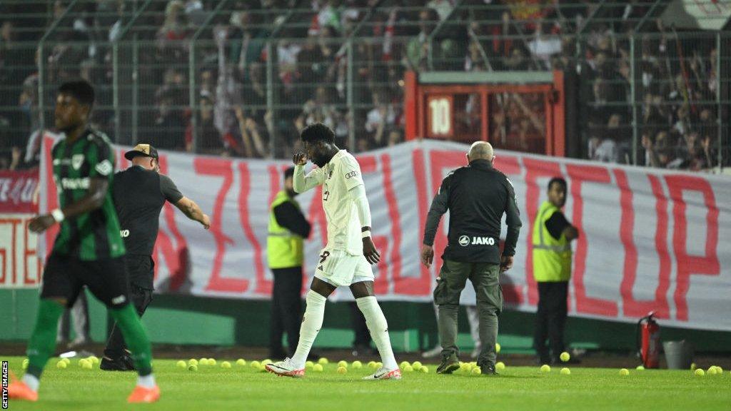 Tennis balls are thrown on to the pitch by Bayern Munich fans