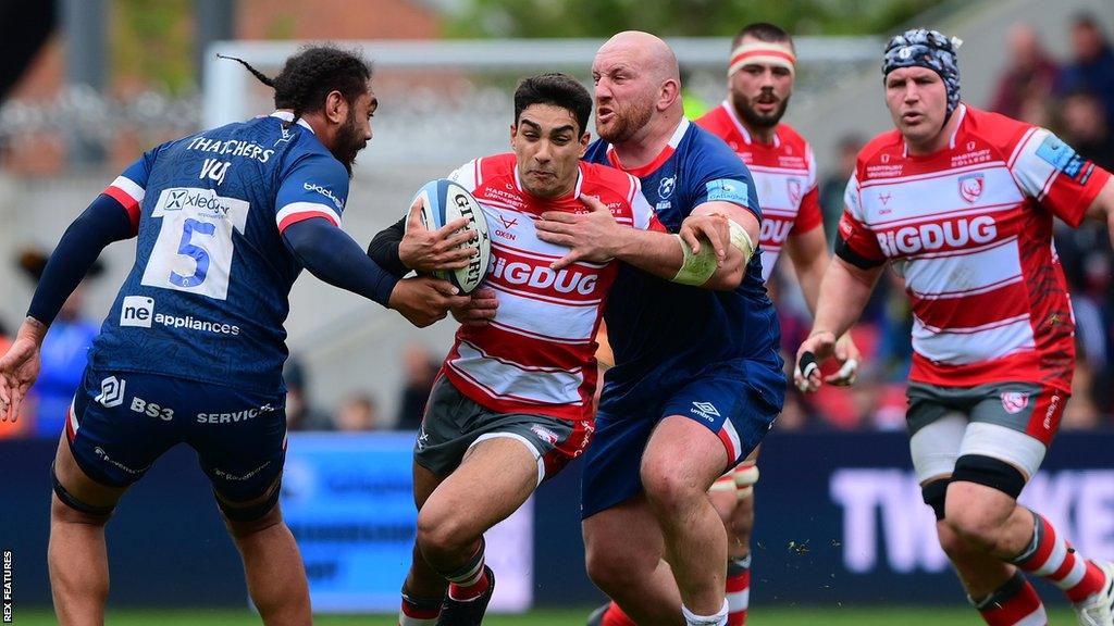 Santiago Carreras is tackled with the ball by two Bristol players during a game last season