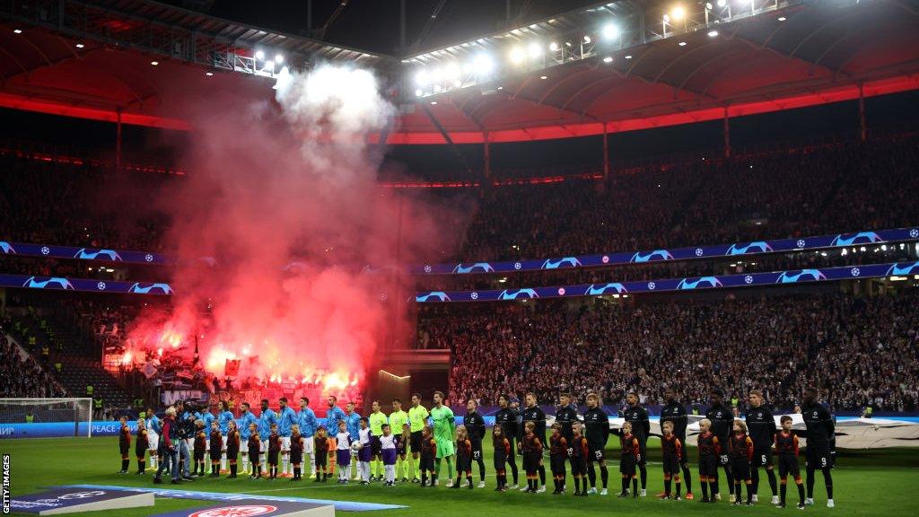 Supporters of Olympique Marseille burn flares as players line up prior to the UEFA Champions League group D match between Eintracht Frankfurt and Olympique Marseille at Deutsche Bank Park