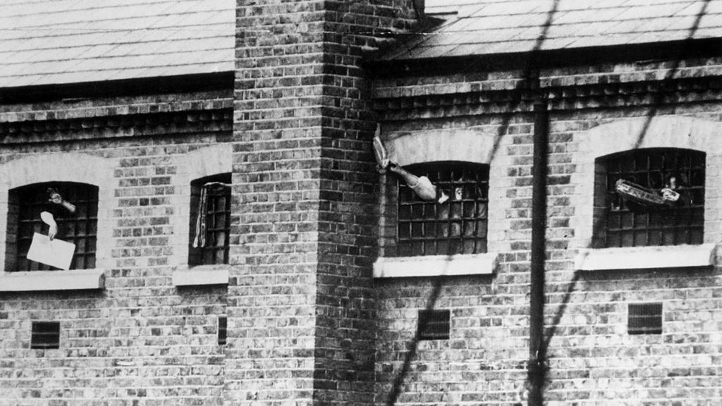 Imprisoned suffragettes waving through the barred windows of Holloway Prison, London, 1909.