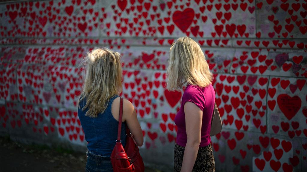 People look at messages and hearts on the National Covid Memorial Wall, dedicated to those who lost their lives to Covid-19, on the embankment on the south side of the River Thames in London on 13 June 2023