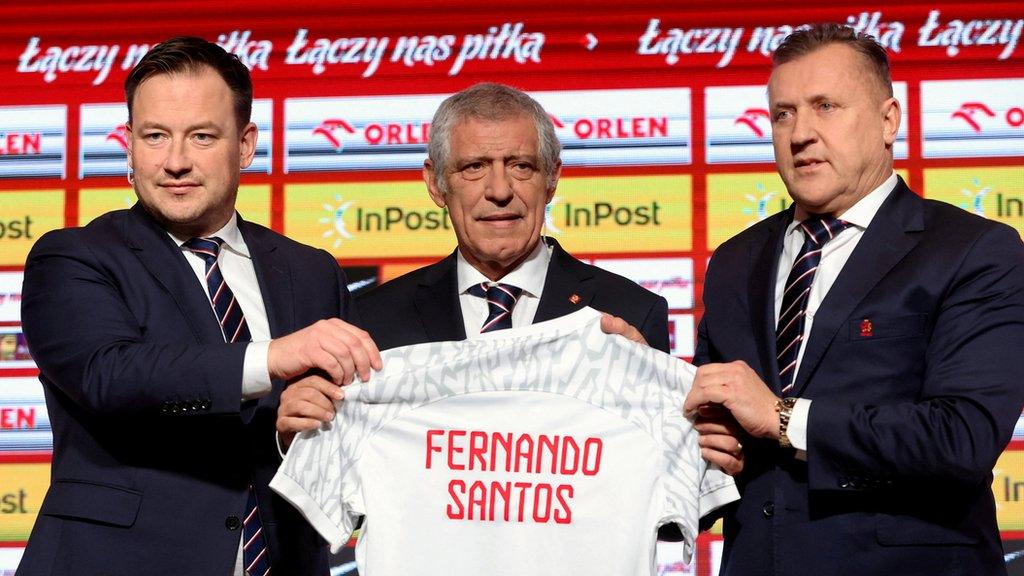 Fernando Santos holding up a Poland shirt