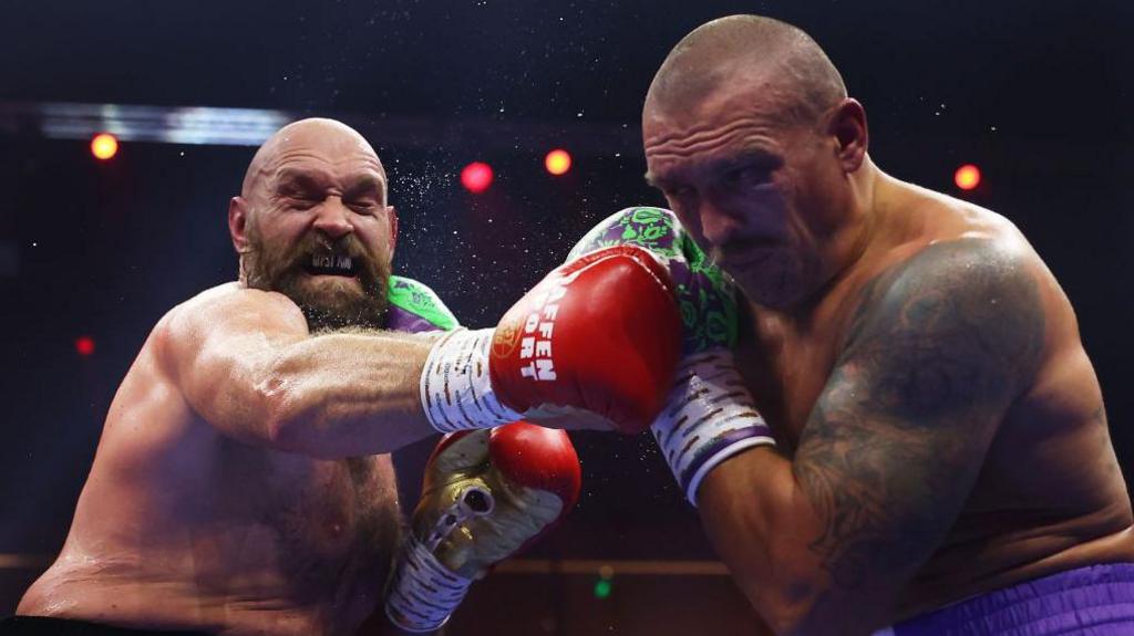 Tyson FUry and Oleksandr Usyk punch each other