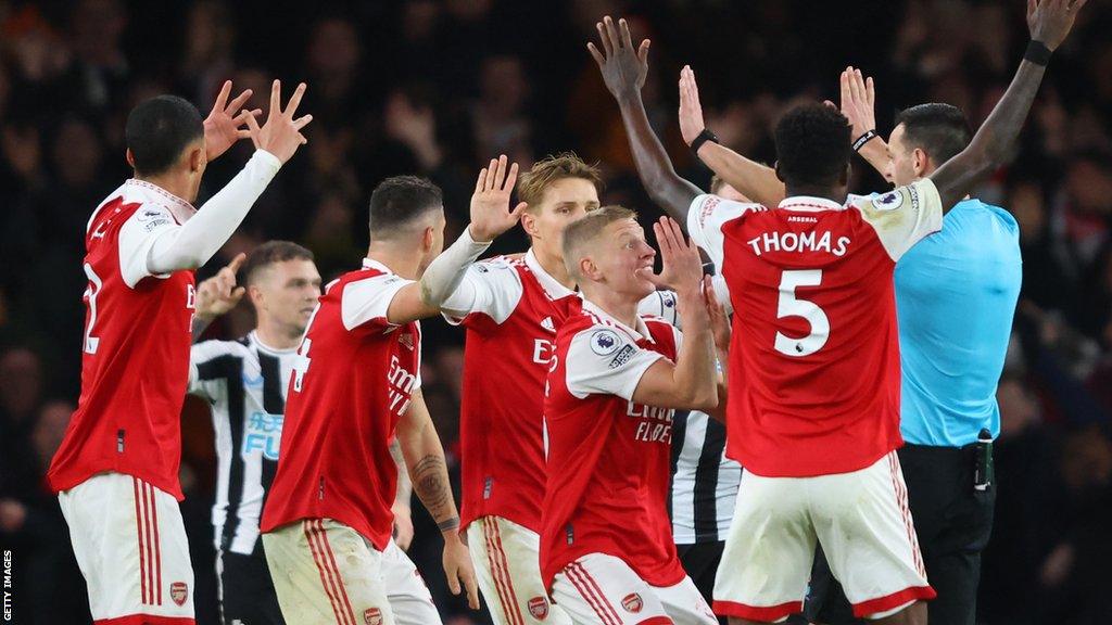 Arsenal players surround a referee during a game last season