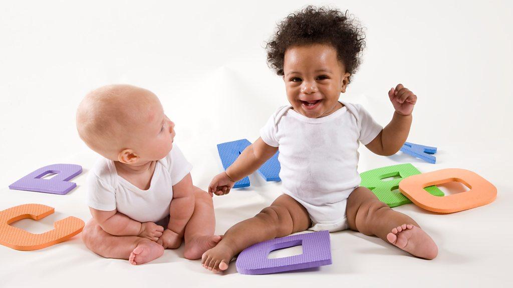 Two babies playing with letters