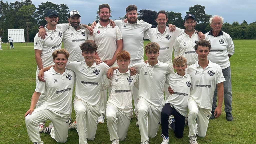 Group of men and boys wearing cricket whites 