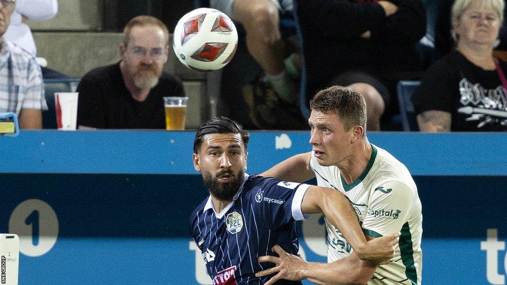 Luzern's Kemal Ademi (L) and Hibernian's Will Fish in action during a UEFA Conference League Qualifier between FC Luzern and Hibernian at the Swissporarena,