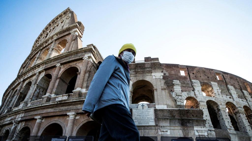 Tourist walks outside colosseum