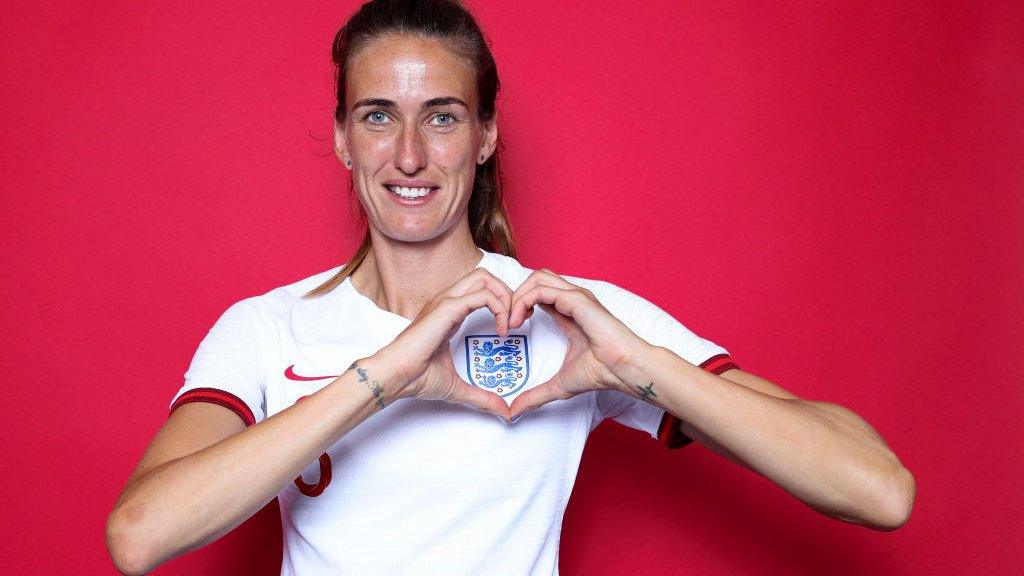 Jill Scott making a heart over England badge