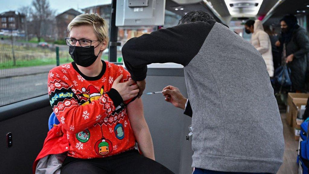 Man in Christmas jumper being vaccinated