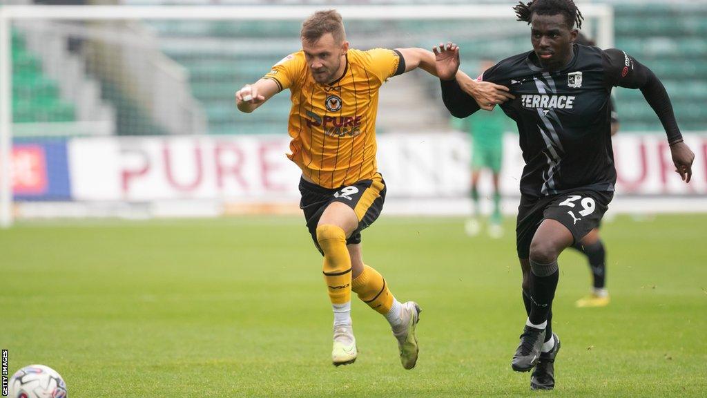 Junior Tiensia (right) in action for Barrow AFC against Newport County's Shane McLoughlin