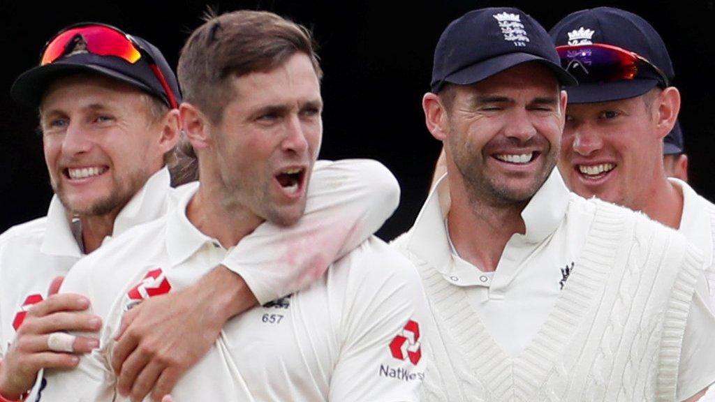 Joe Root and James Anderson congratulate Chris Woakes on a wicket