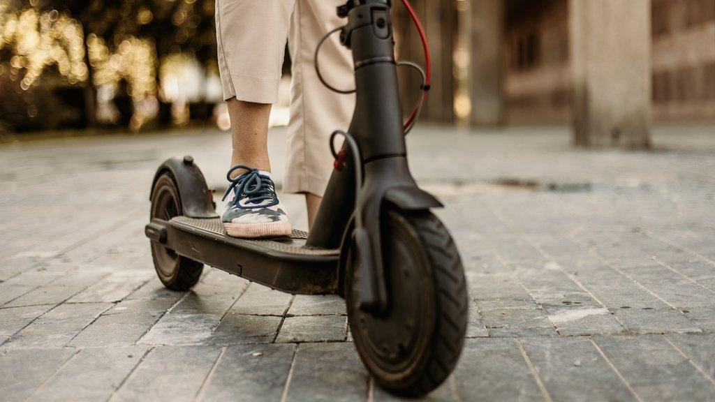 A stock closeup of a person on an e-scooter