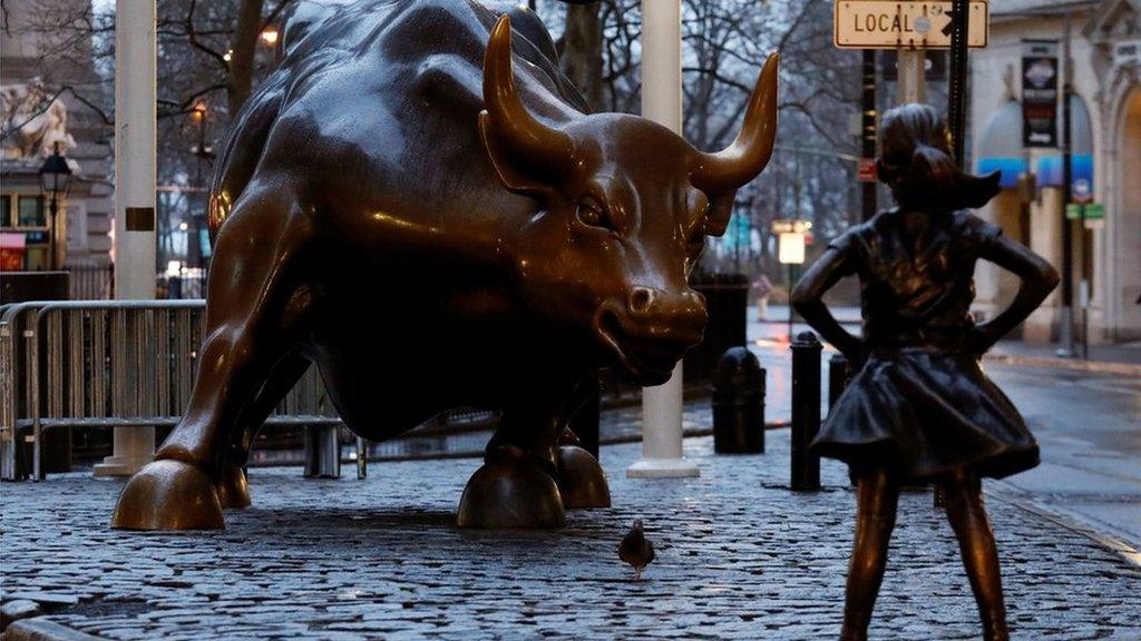 A statue of a girl facing the Wall St bull