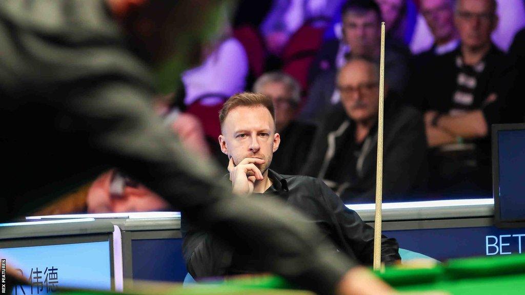 Judd Trump sits and watches as Daniel Wells makes a break