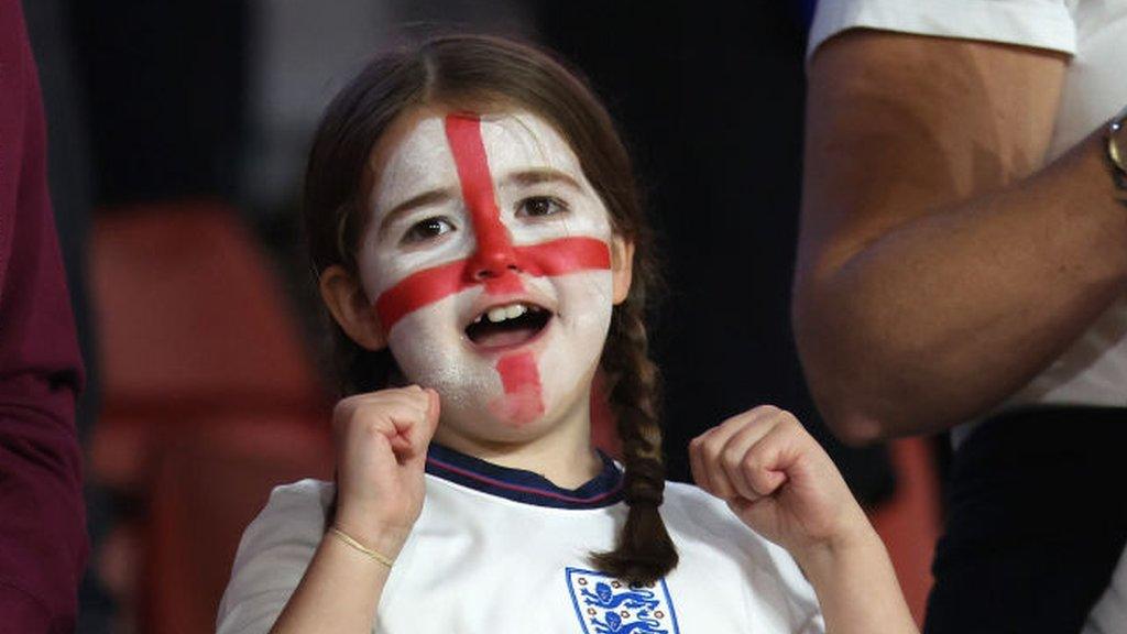 girl in crowd in England shirt singing