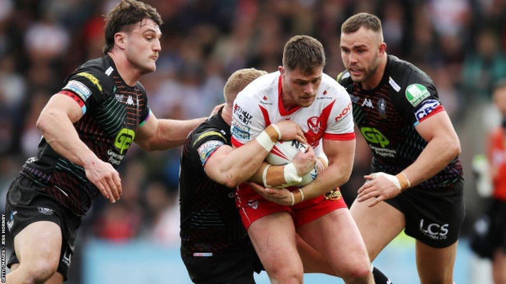 St Helens forward Morgan Knowles is halted by Wigan pair Liam Byrne and Kaide Ellis