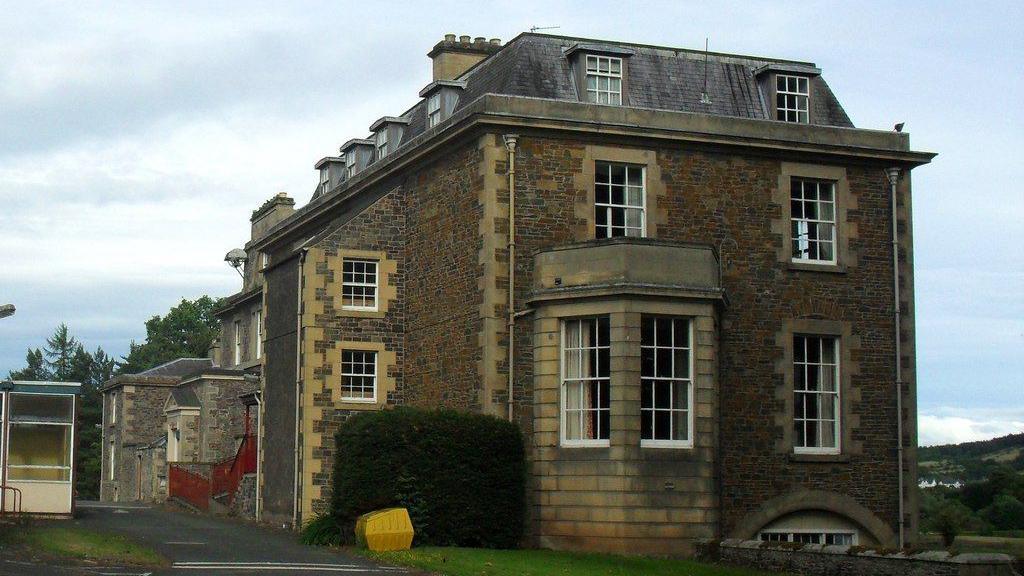 A 230-year-old historic house in the Borders with an imposing facade and lots of windows against a grey sky