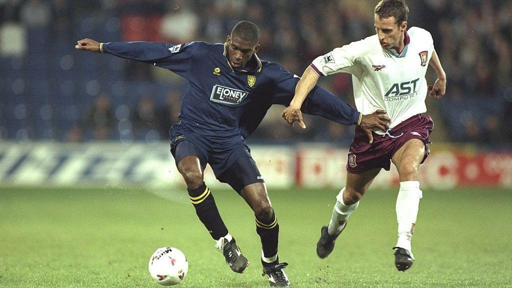 Efan Ekoku (left) holds off future England manager Gareth Southgate as Wimbledon take on Aston Villa in 1997