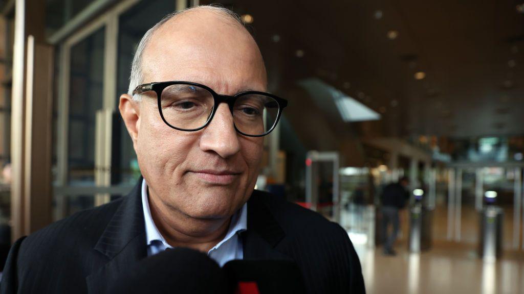 Close-up shot of Iswaran wearing black spectacles outside Singapore's court