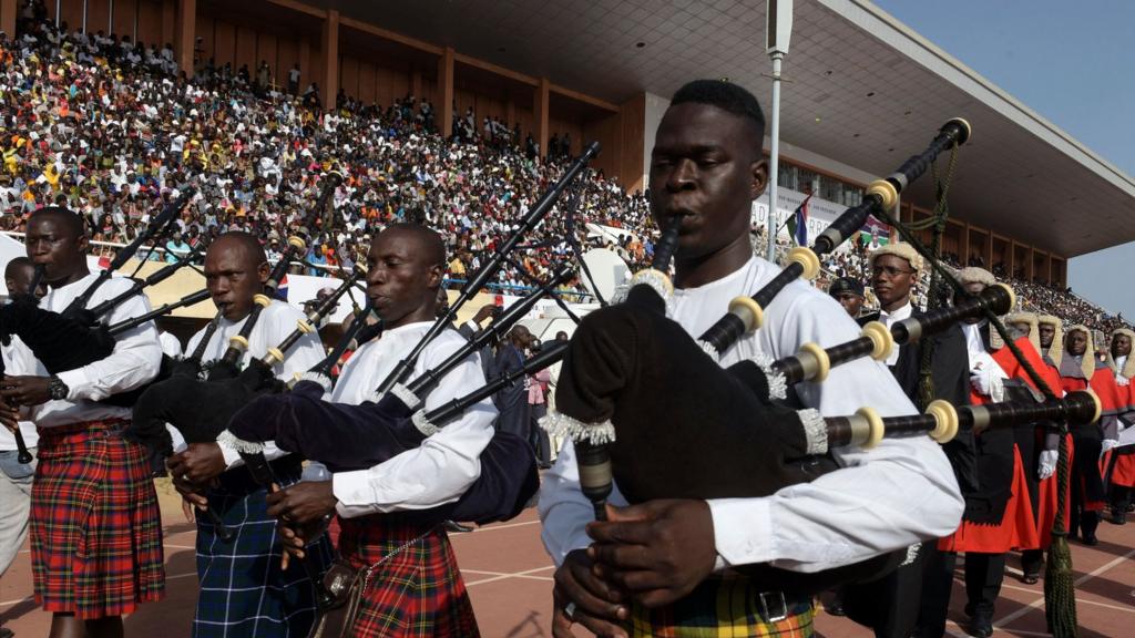 Musicians playing the bagpipes lead the Gambian court as they parade during the inauguration ceremony for the start of Barrow's presidency at the Independence Stadium in Bakau