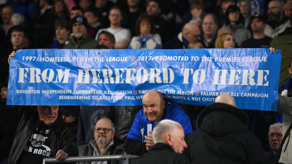 Fans of Brighton & Hove Albion show their support with a banner reading 'From Hereford to here' during the UEFA Europa League round of 16 second leg match between Brighton & Hove Albion and AS Roma. 