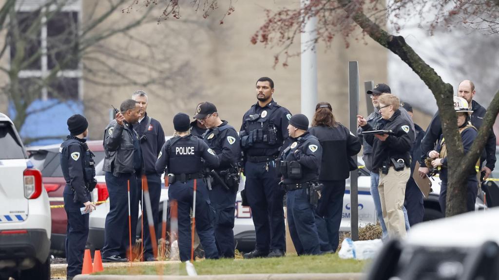 Police officers on the scene of shooting, dressed in blue  