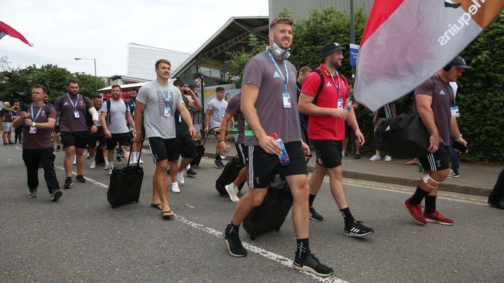 Stephan Lewies and Harlequins players walk down the road past Twickenham Stoop