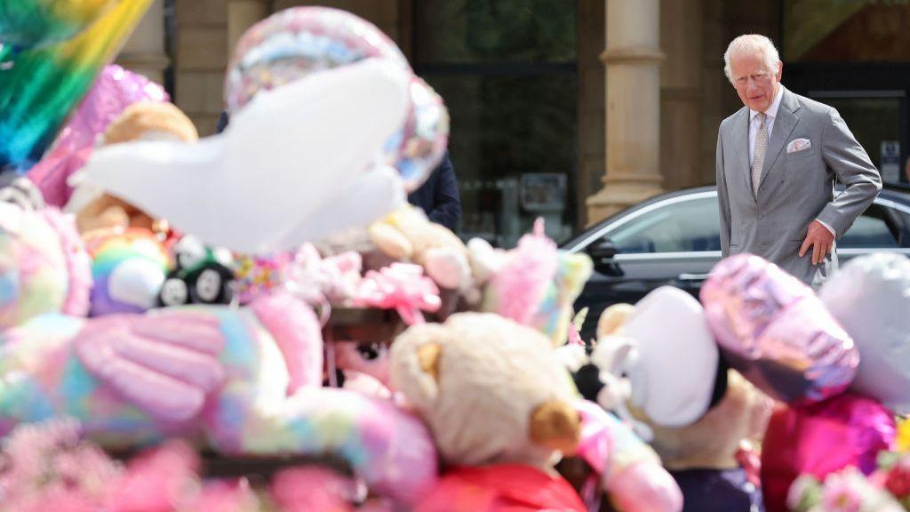 King Charles III reacts as he views the floral and balloon tributes for the victims of the Southport stabbings outside Southport Town Hall