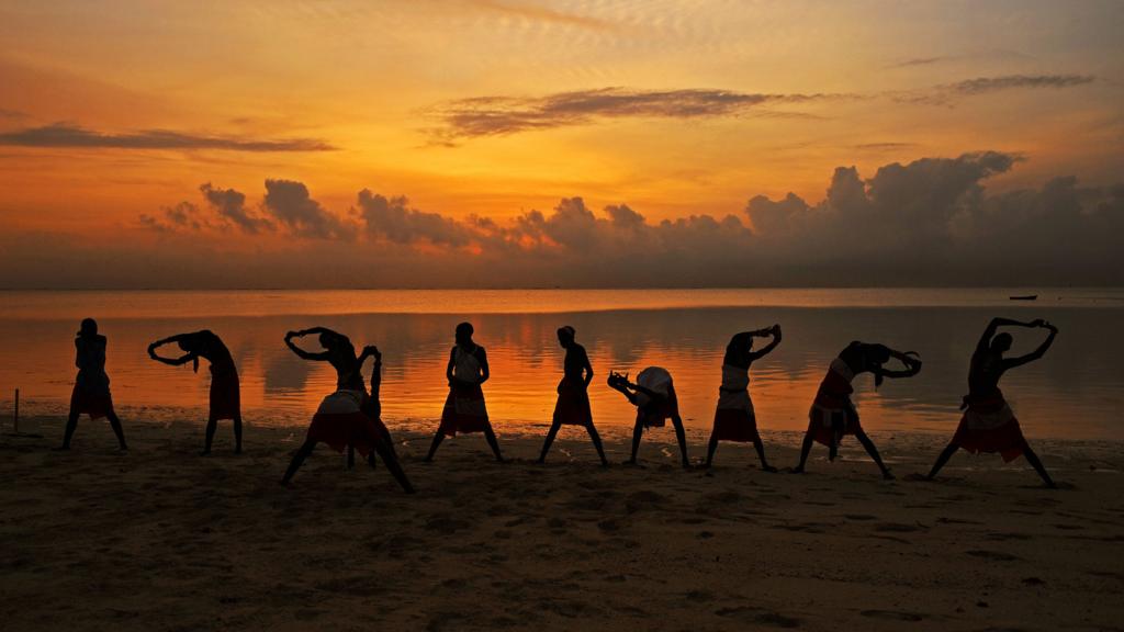 Maasai cricketers exercising on a beach in Mombasa, Kenya