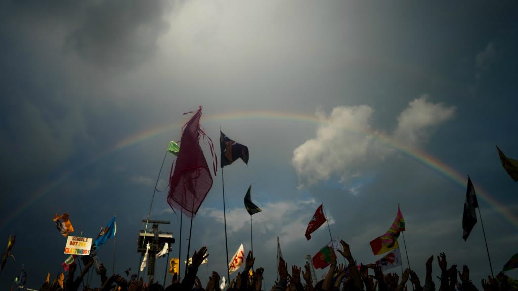 A rainbow is cast over Glastonbury revellers