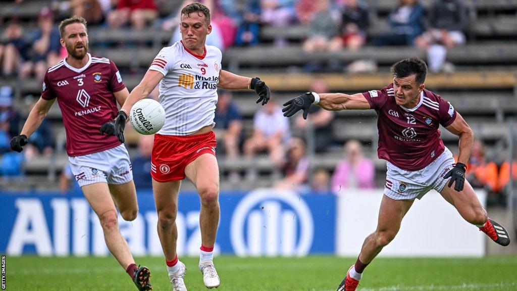 Tyrone's Conn Kilpatrick gets in a shot despite the efforts of Westmeath duo Kevin Maguire and David Lynch