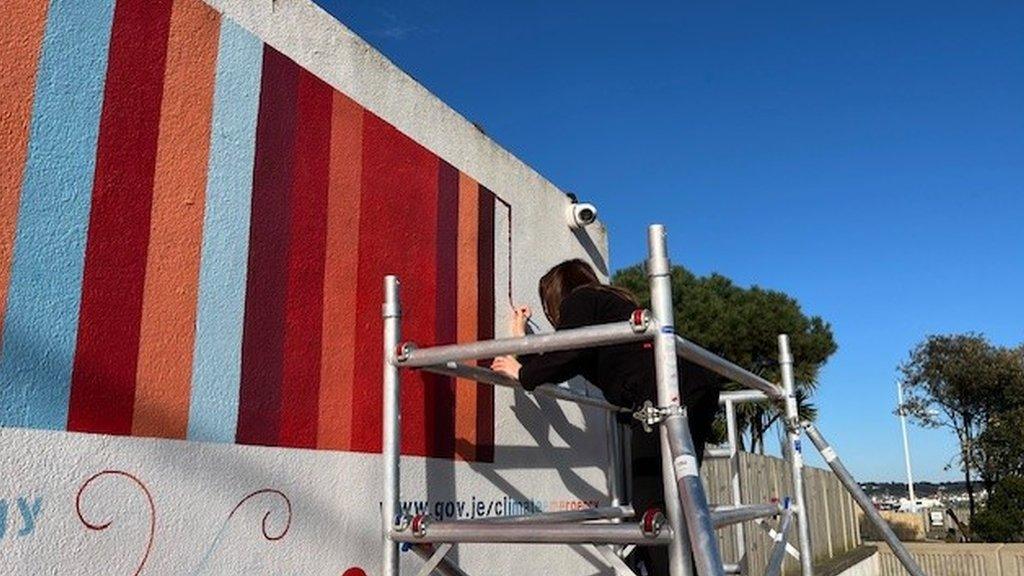 Woman painting the 130th strip on the wall